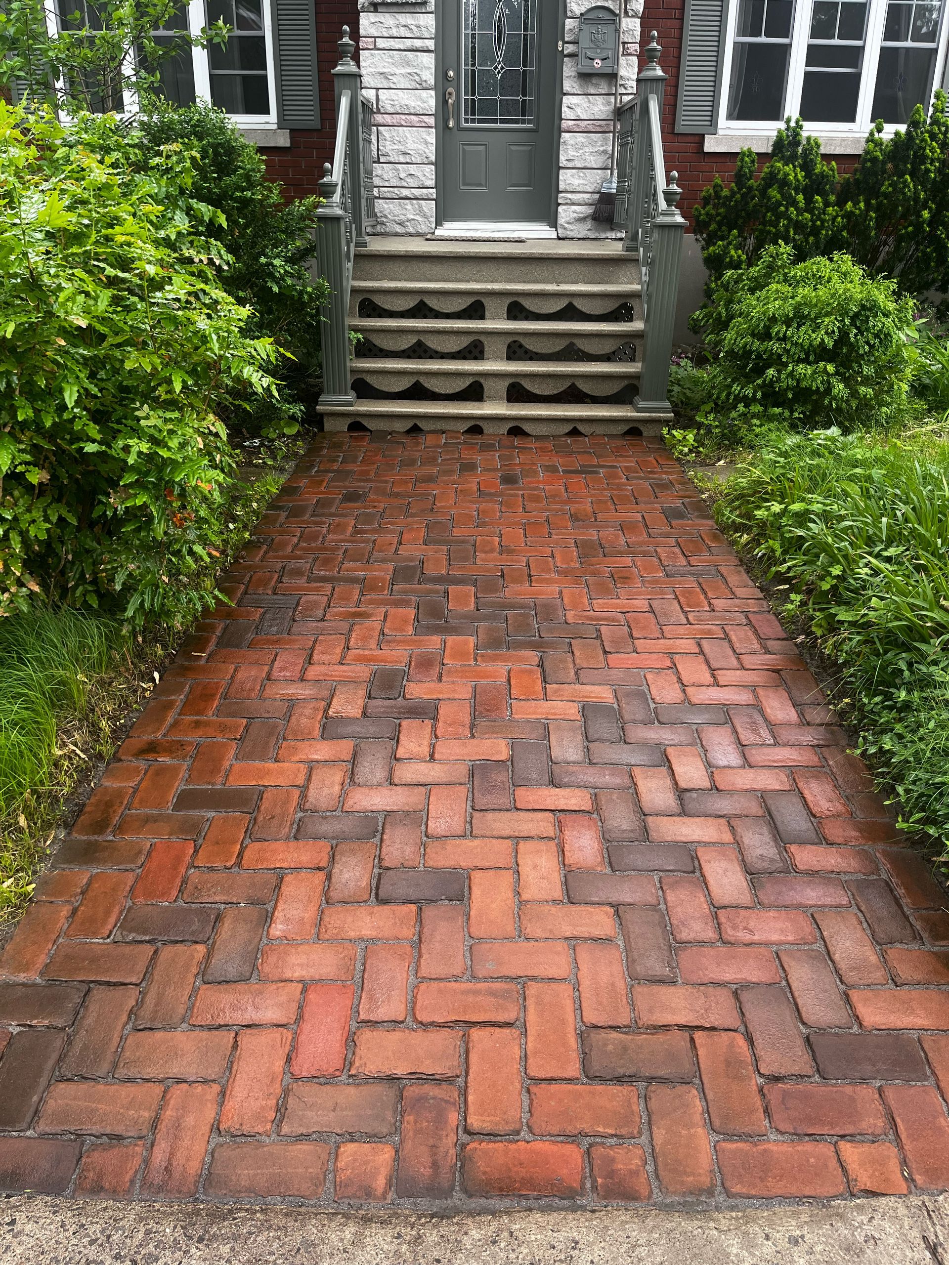 Une allée en briques menant à la porte d'entrée d'une maison.