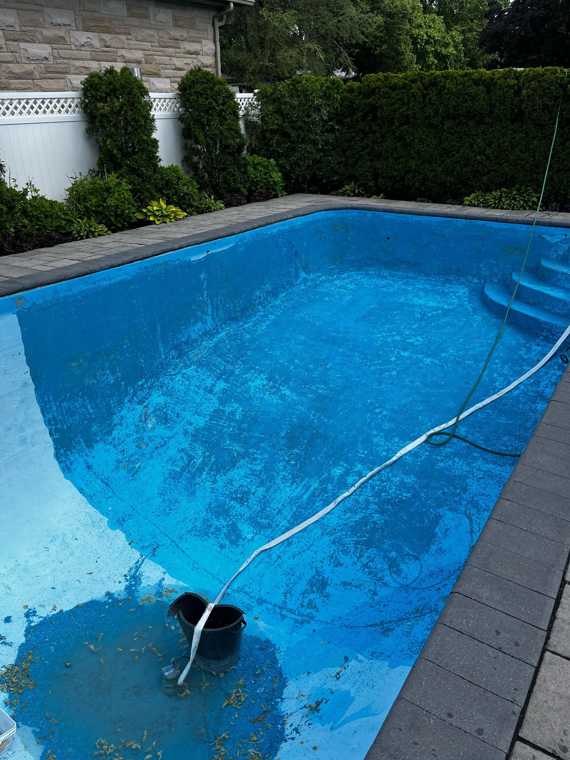 Une grande piscine bleue avec un tuyau attaché.