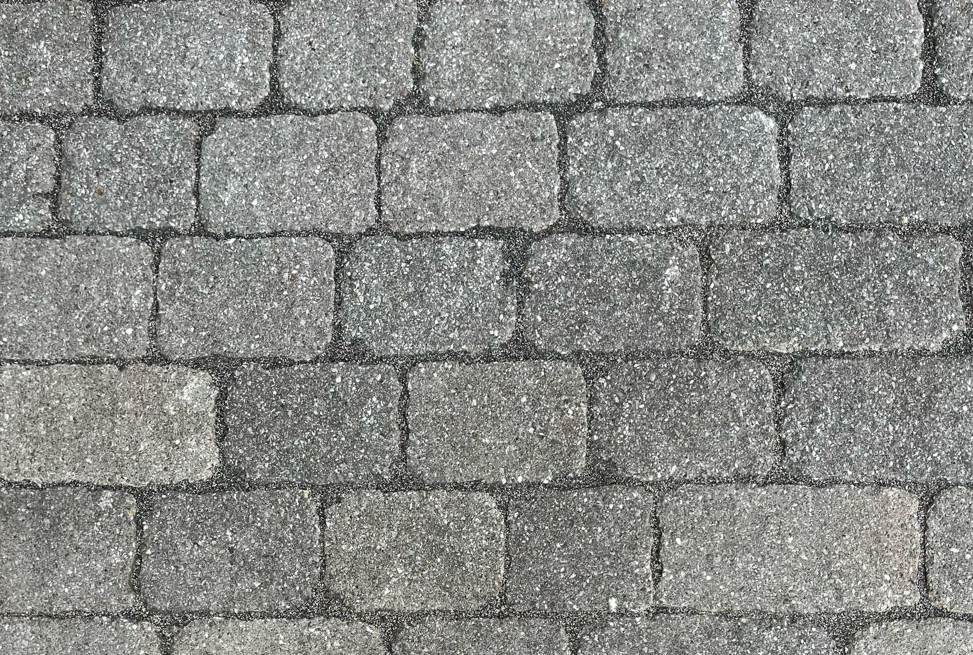 Gros plan sur un motif de pavés dans des tons de gris.