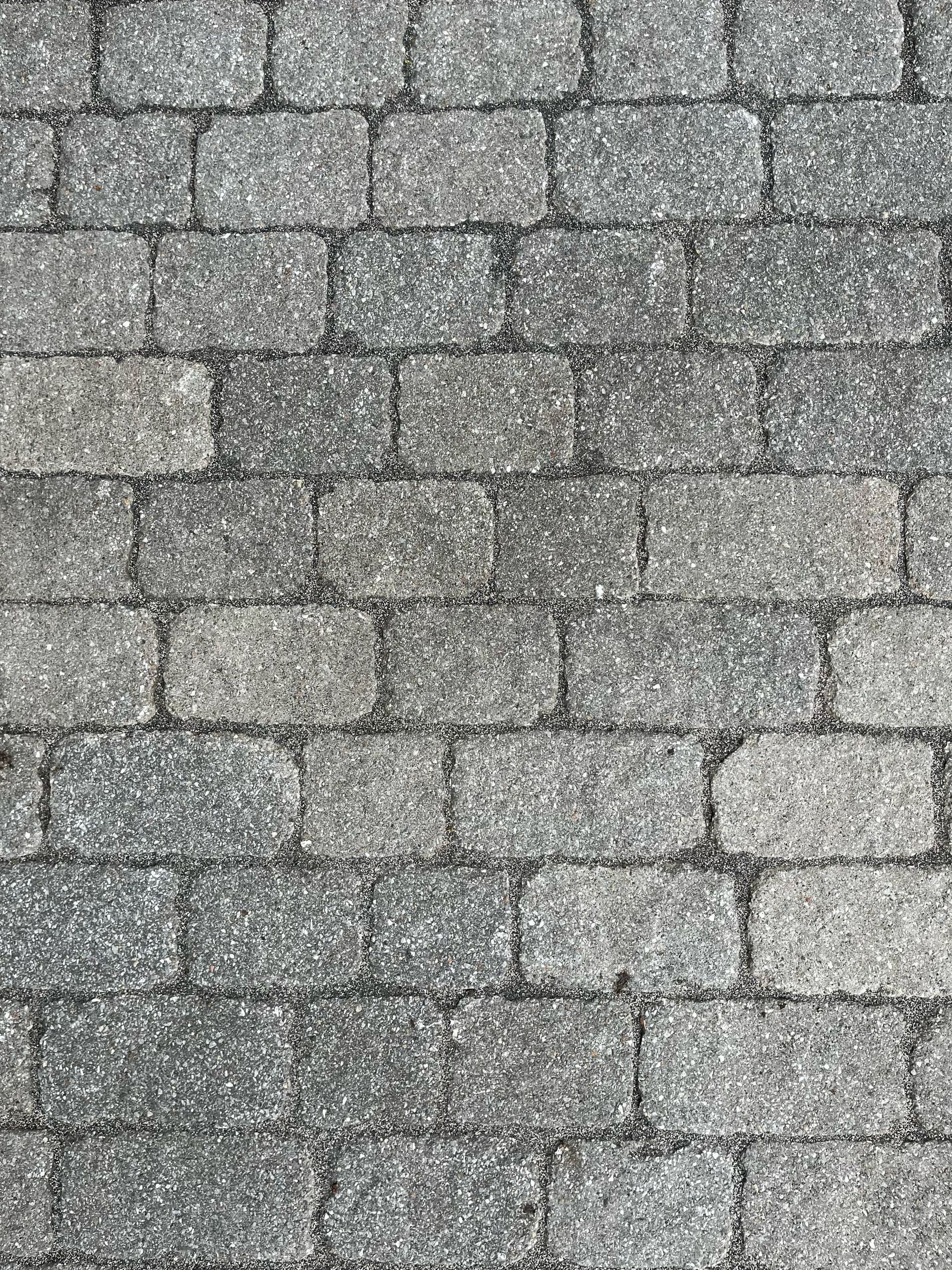 Pavés de brique grise posés en appareil décalé.
