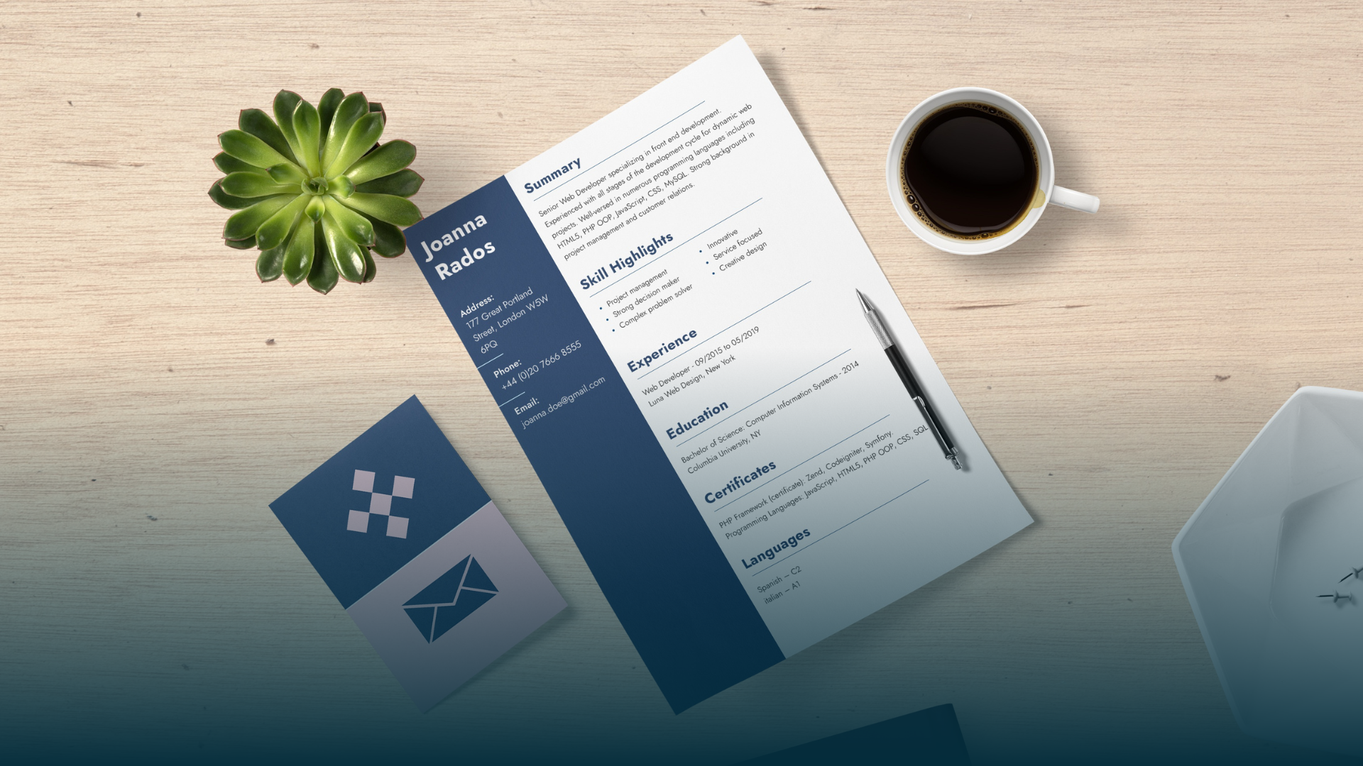 Resume on a desk with a succulent, coffee, pen, and envelope with a logo.