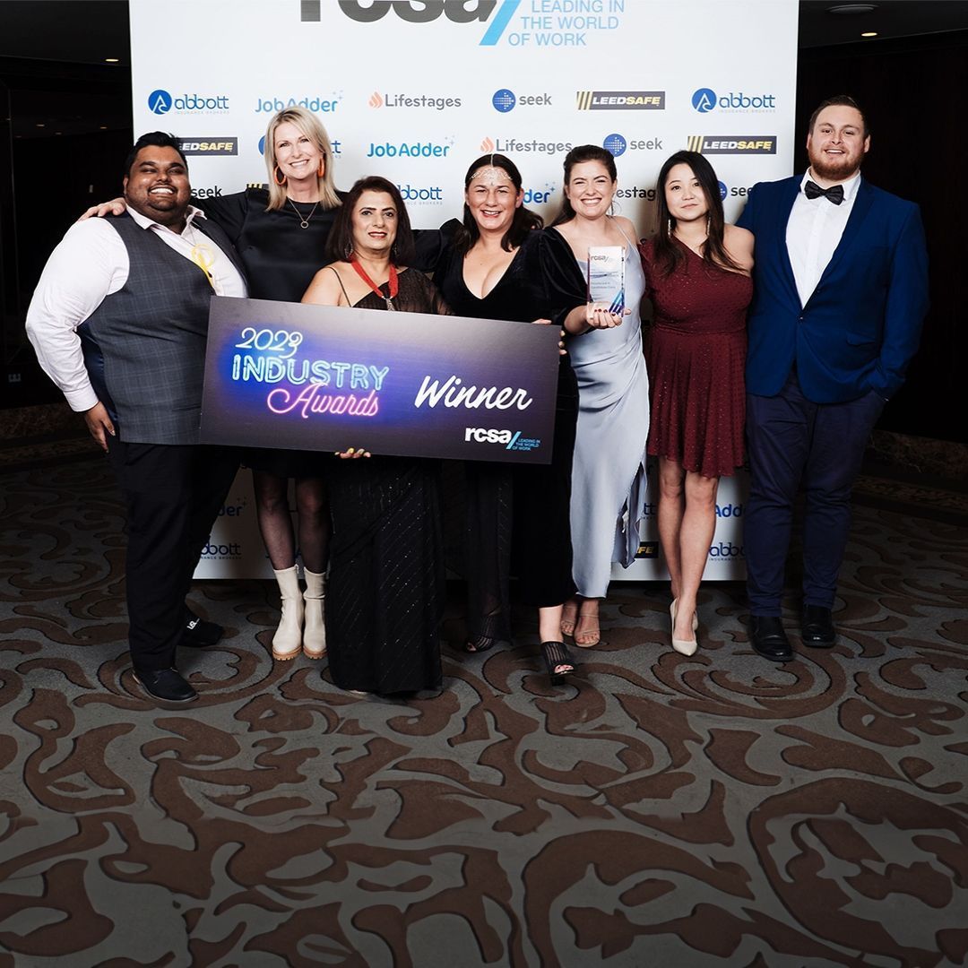 Group of people holding an award sign that reads 
