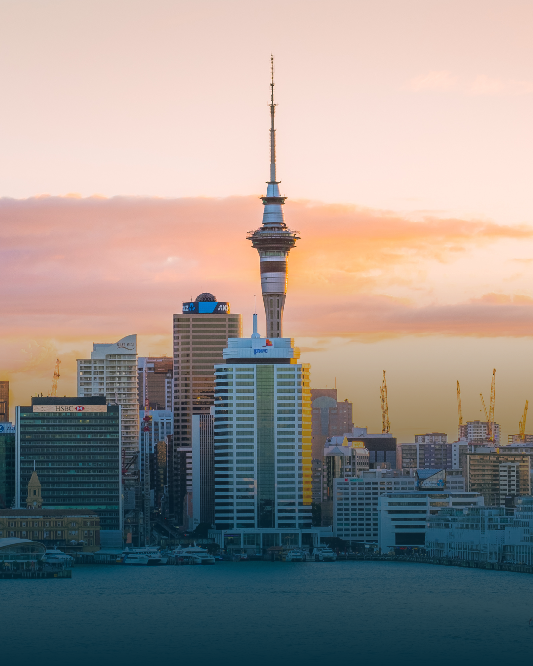 Sky Tower and Auckland skyline at sunset.