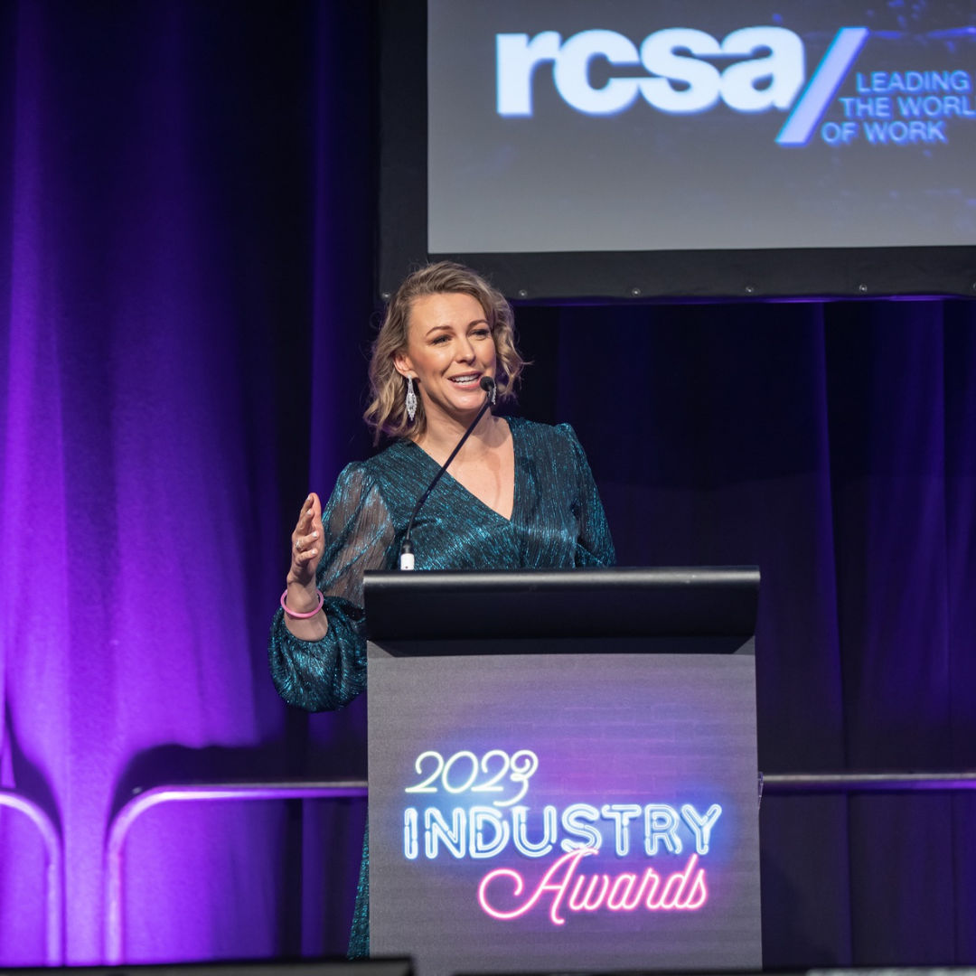 Woman speaking at a podium with 