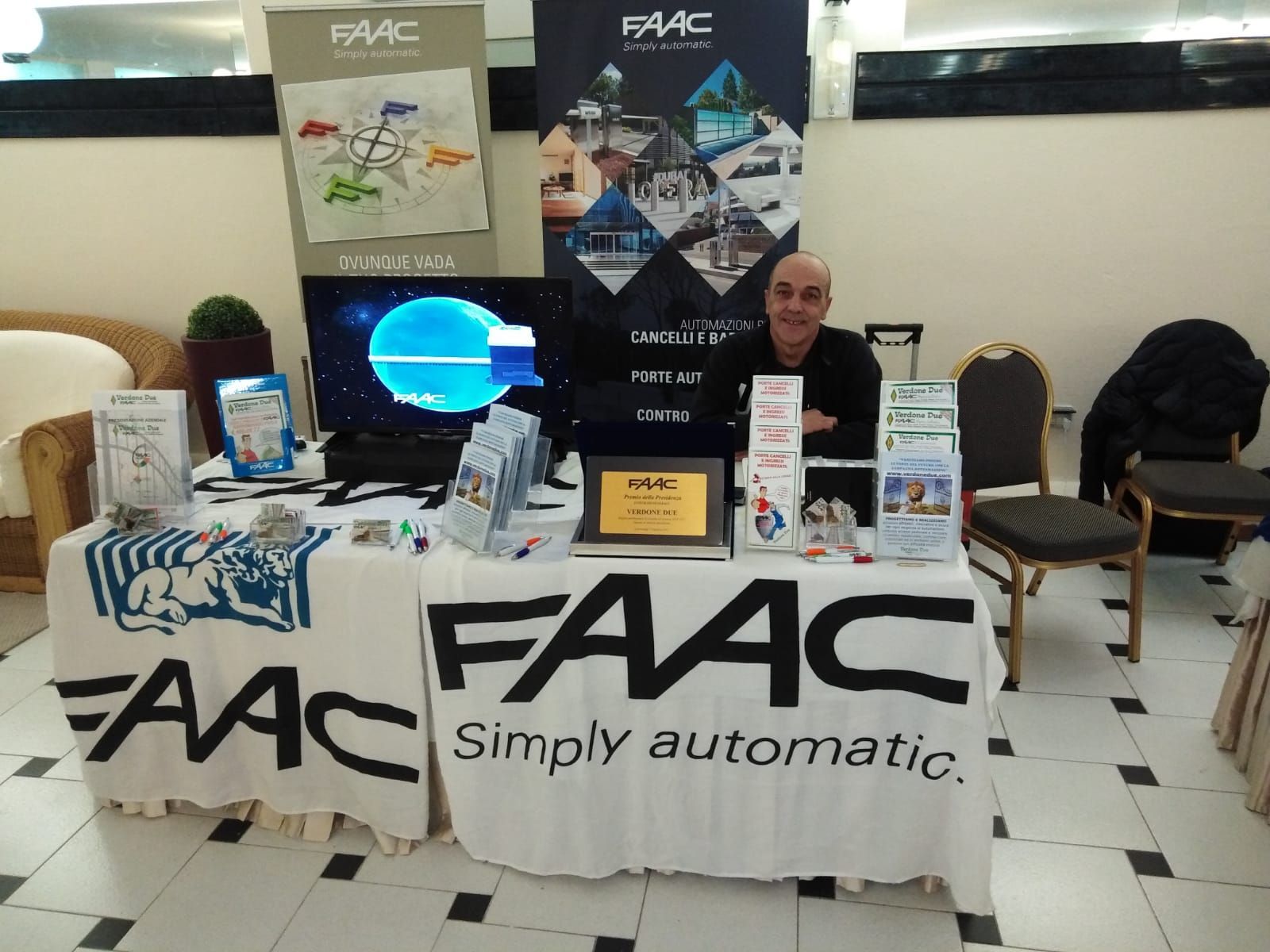Un uomo è seduto dietro un tavolo su cui è scritto FAAC Simply Automatic
