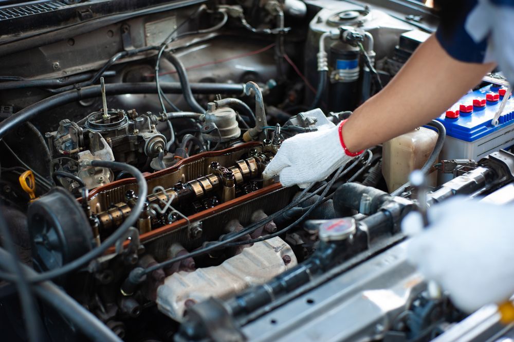 Mechanic in white gloves inspecting a car engine with a wrench in the engine bay  — Bundaberg Field Service in Bundaberg East, QLD