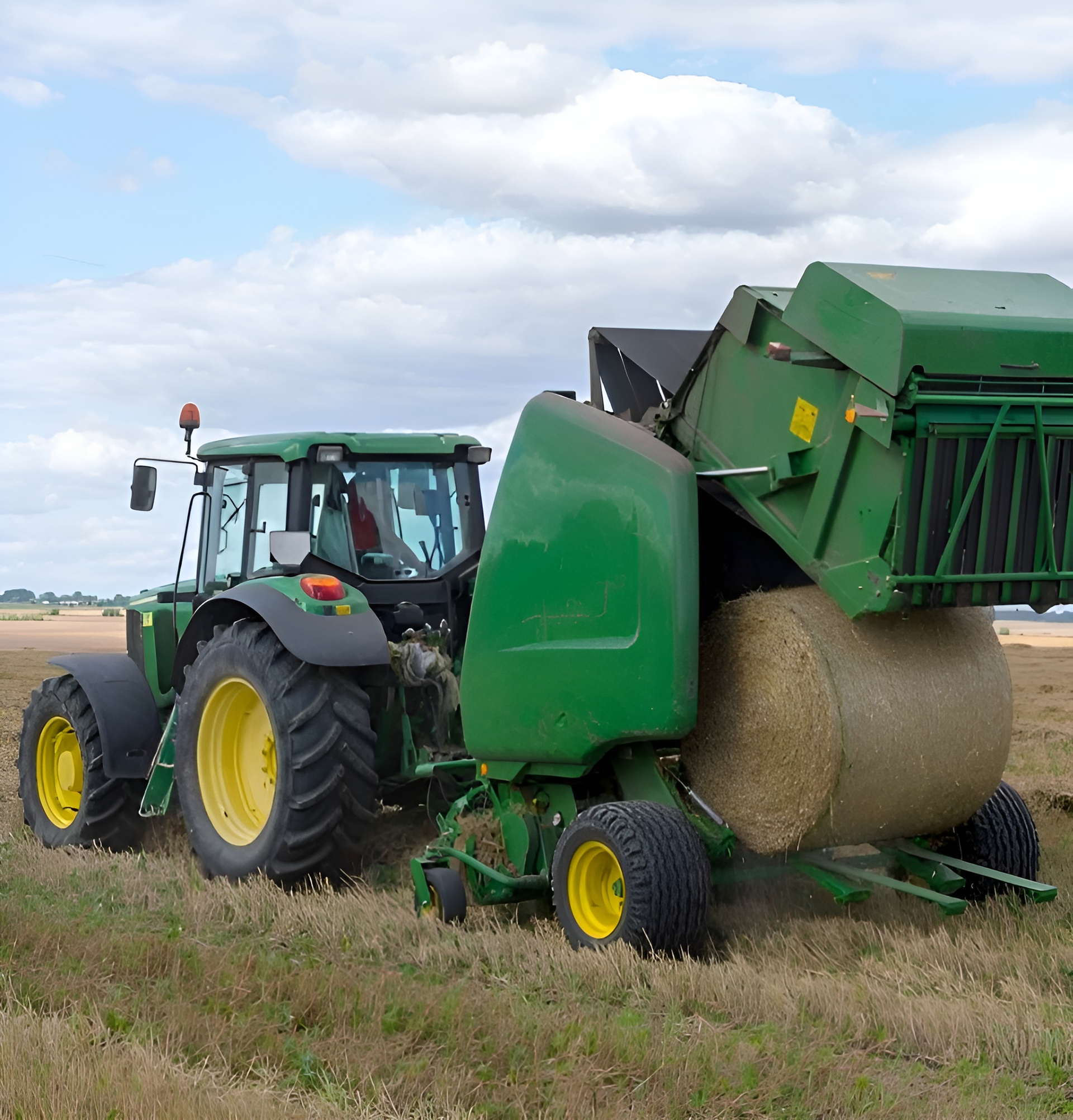 Green tractor wrapping a large round hay bale in a field under a cloudy sky — Bundaberg Field Service in Bundaberg East, QLD
