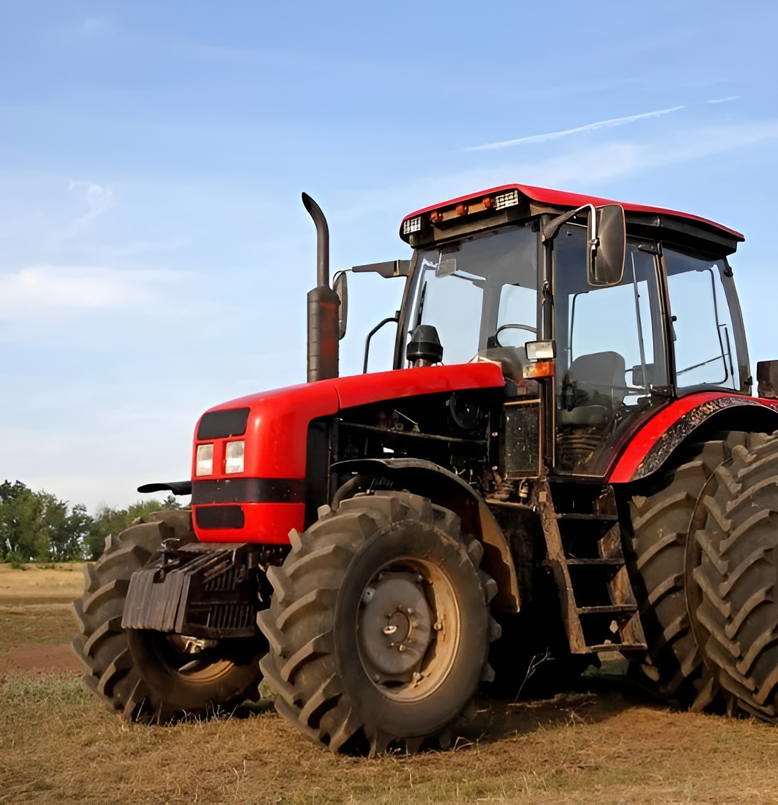 Red Tractor in A Field Under a Blue Sky — Bundaberg Field Service in Bundaberg East, QLD