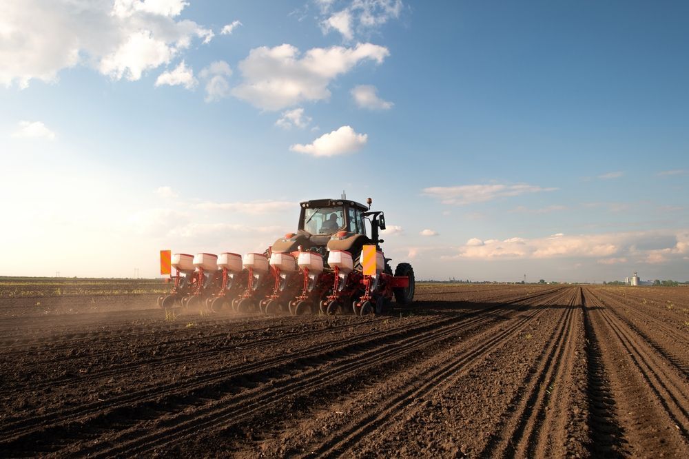 Tractor plowing a field at sunset, leaving rows of tilled soil under a blue sky. — Bundaberg Field Service in Childers, QLD