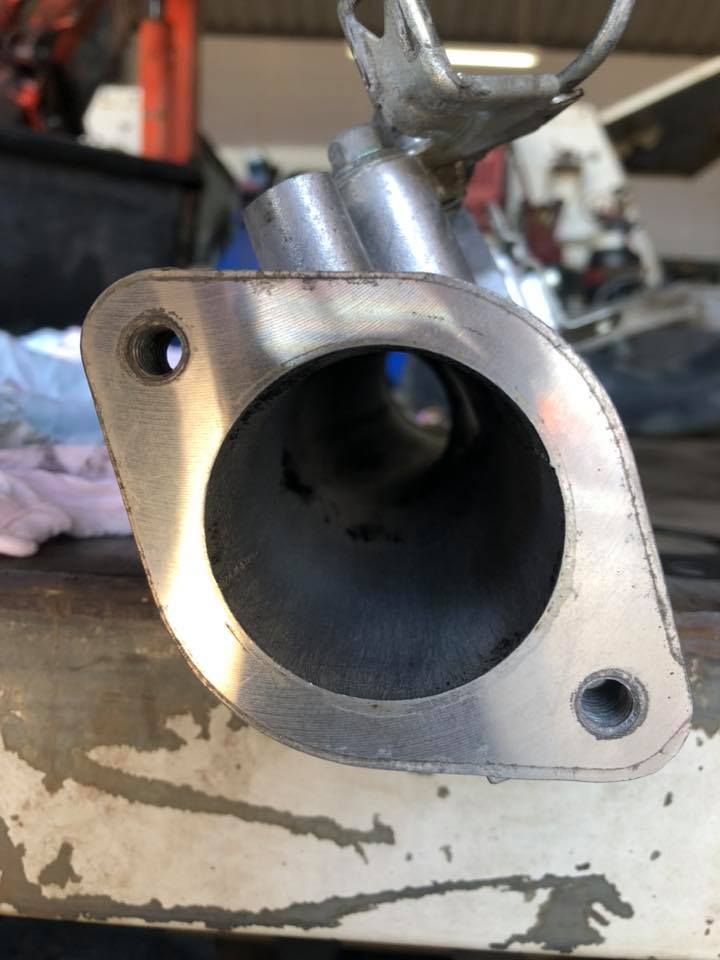 A Metal Exhaust Flange with A Circular Opening and Two Bolt Holes — Bundaberg Field Service in Bundaberg East, QLD