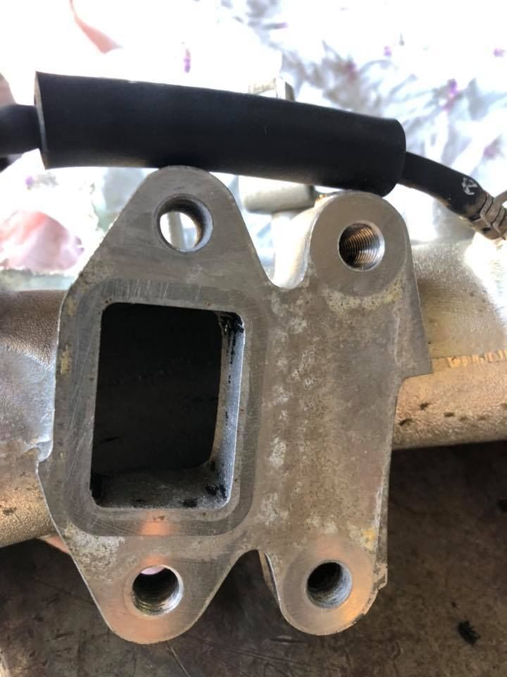 A Metal Engine Part with A Rectangular Opening and Four Bolt Holes — Bundaberg Field Service in Bundaberg East, QLD