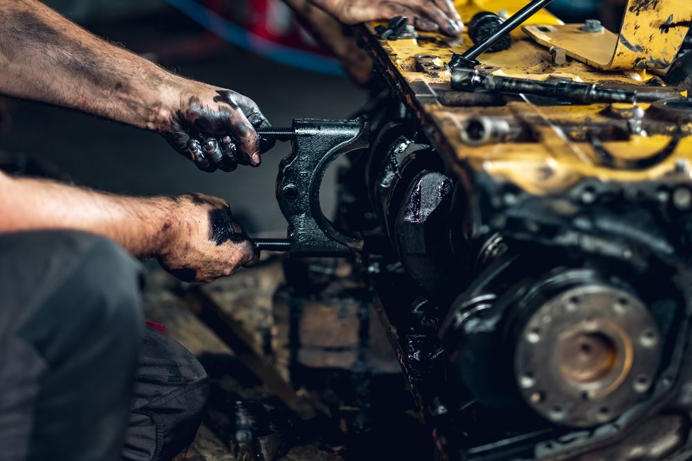Mechanic working on a car engine with greasy hands in a garage — Bundaberg Field Service in Bundaberg East, QLD
