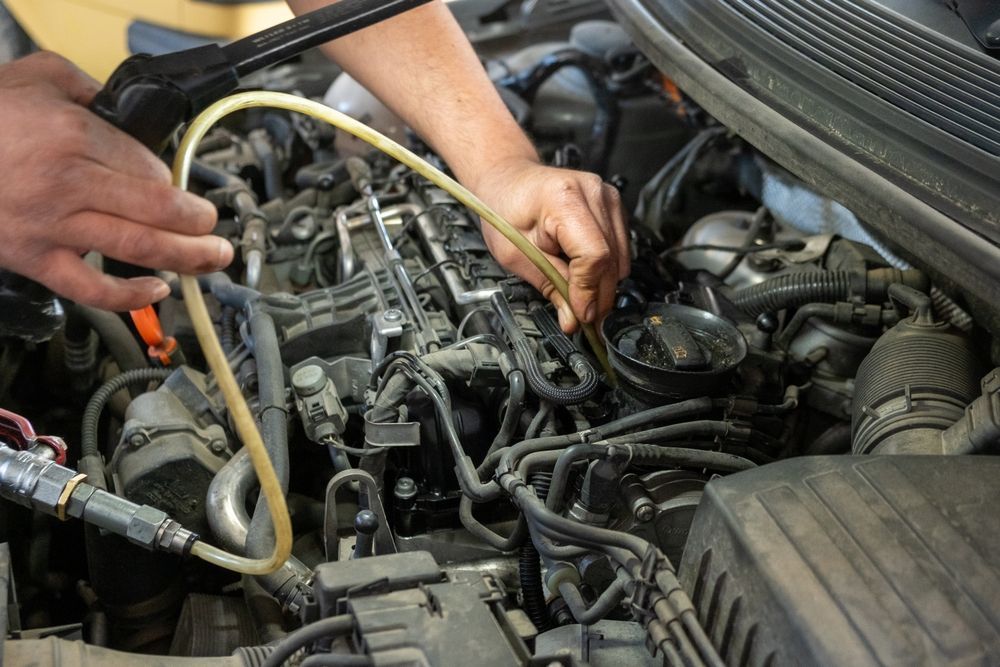 Mechanic using a hose to work on a car engine in a repair bay — Bundaberg Field Service in Bundaberg East, QLD