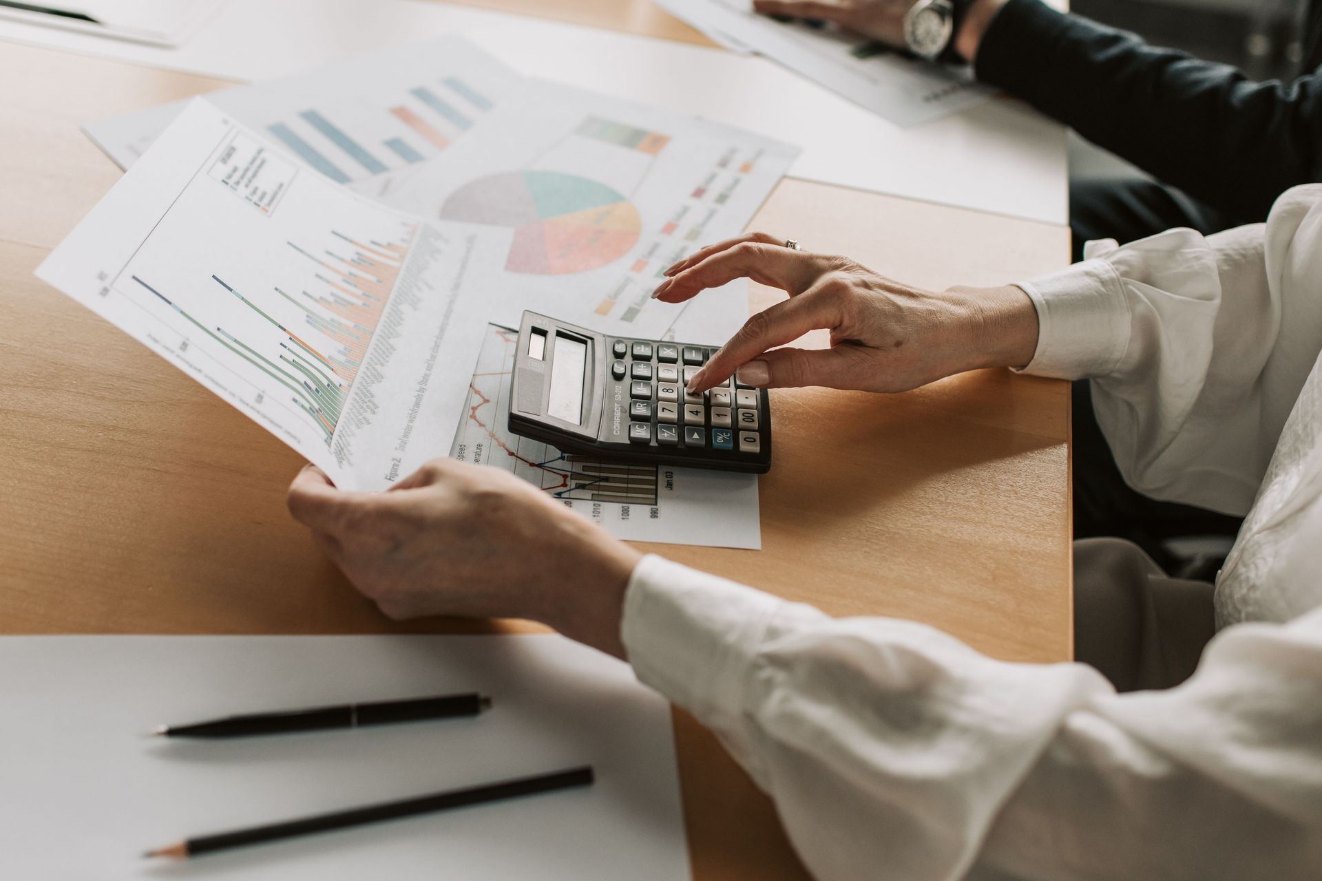 Calculator and financial charts used for pension annual allowance review.