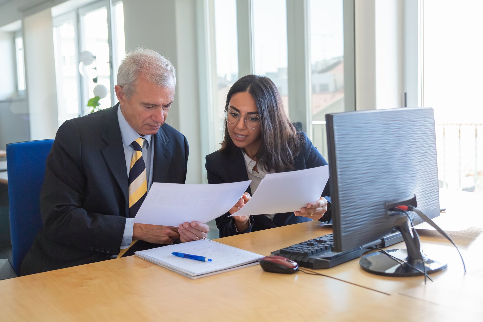 Company director reviewing pension contribution figures with a financial adviser.