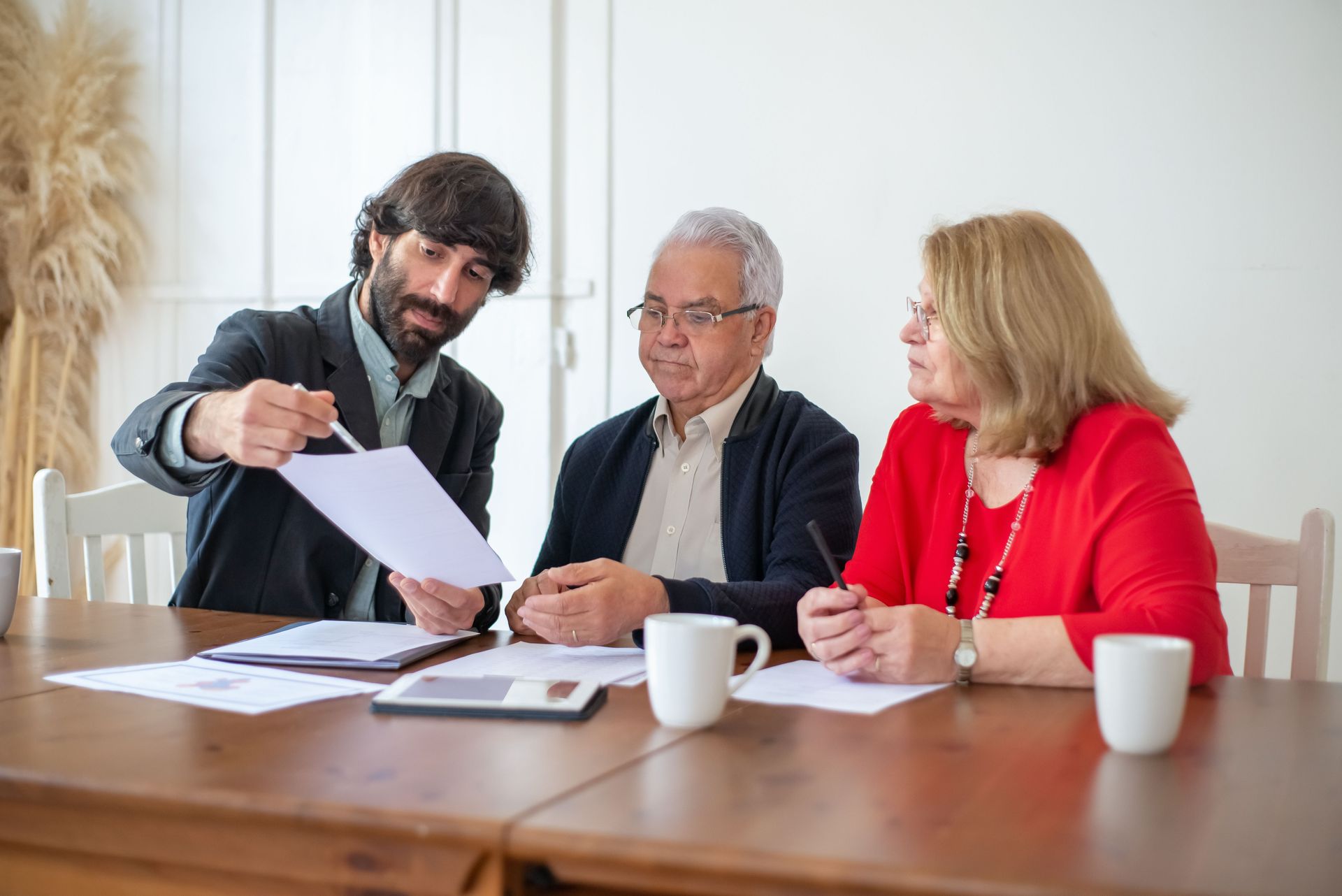 Financial adviser reviewing planning documents with clients at a meeting.
