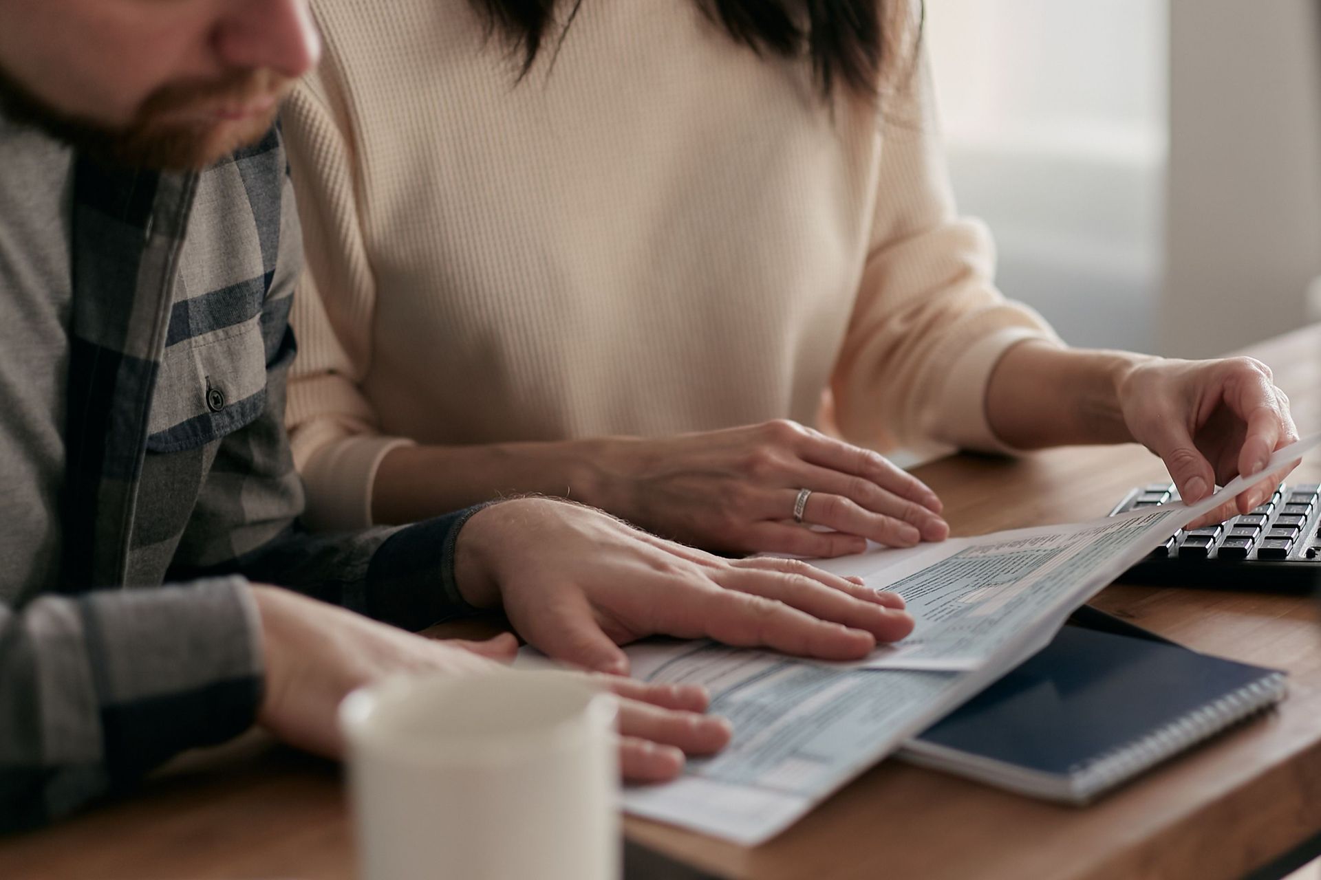 Two people reviewing pension documents and calculations together.