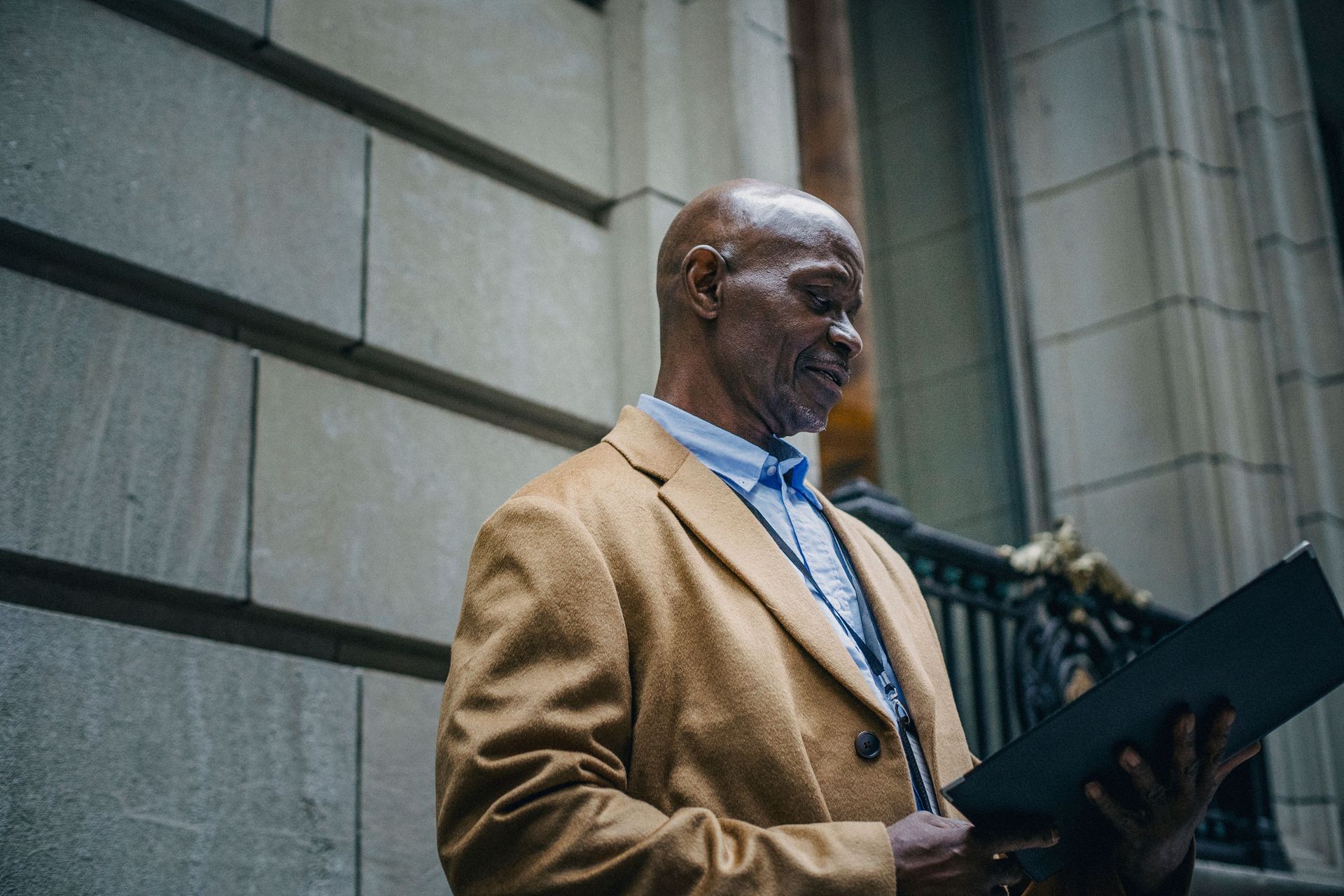 Mature business owner reviewing documents outside a commercial property.