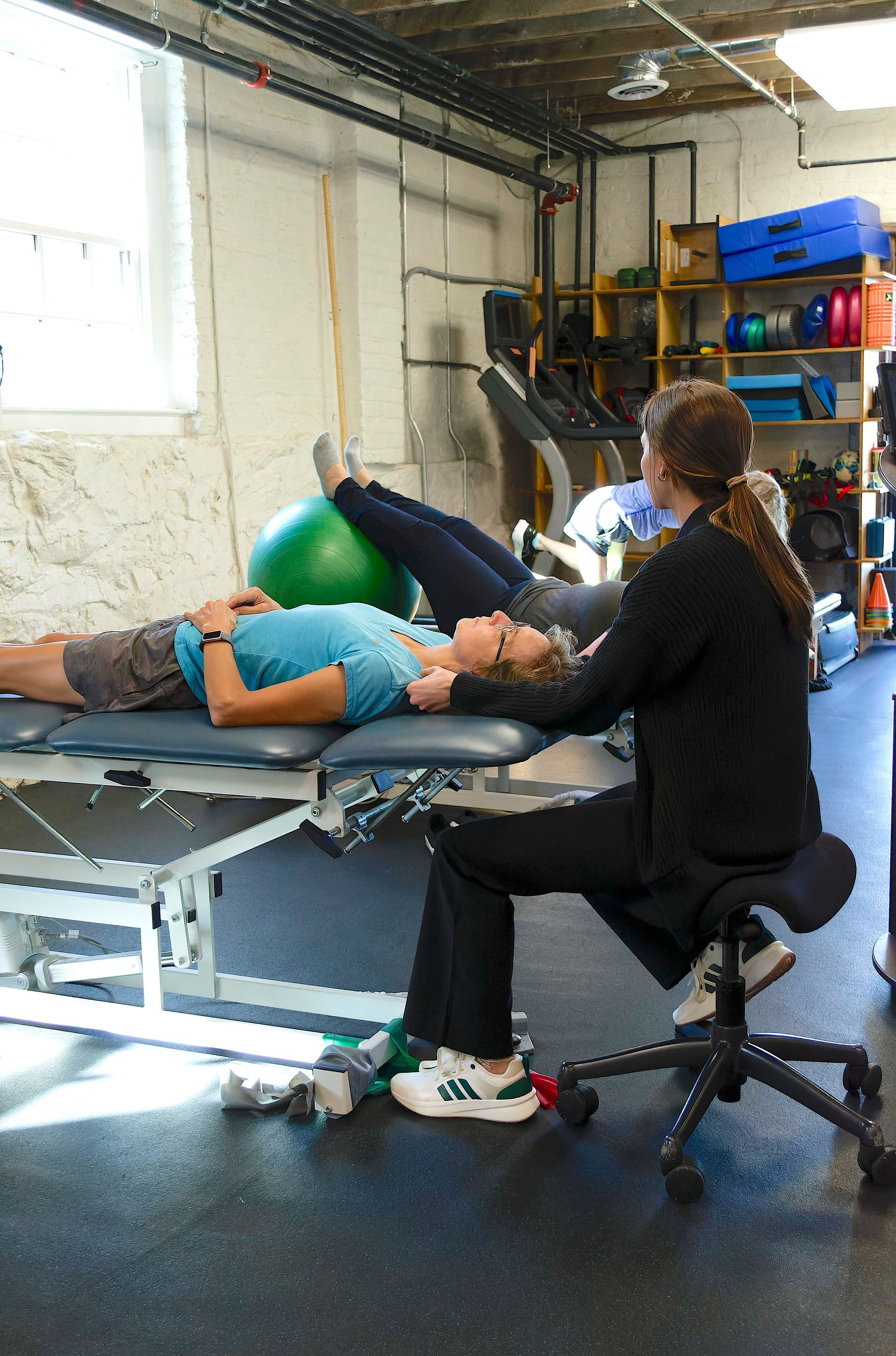 Physical therapist working with a patient on a treatment table in a rehab clinic