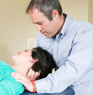 Therapist supporting a reclining patient during a clinical consultation