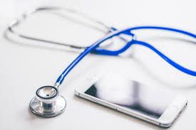 Blue stethoscope beside a smartphone on a white surface
