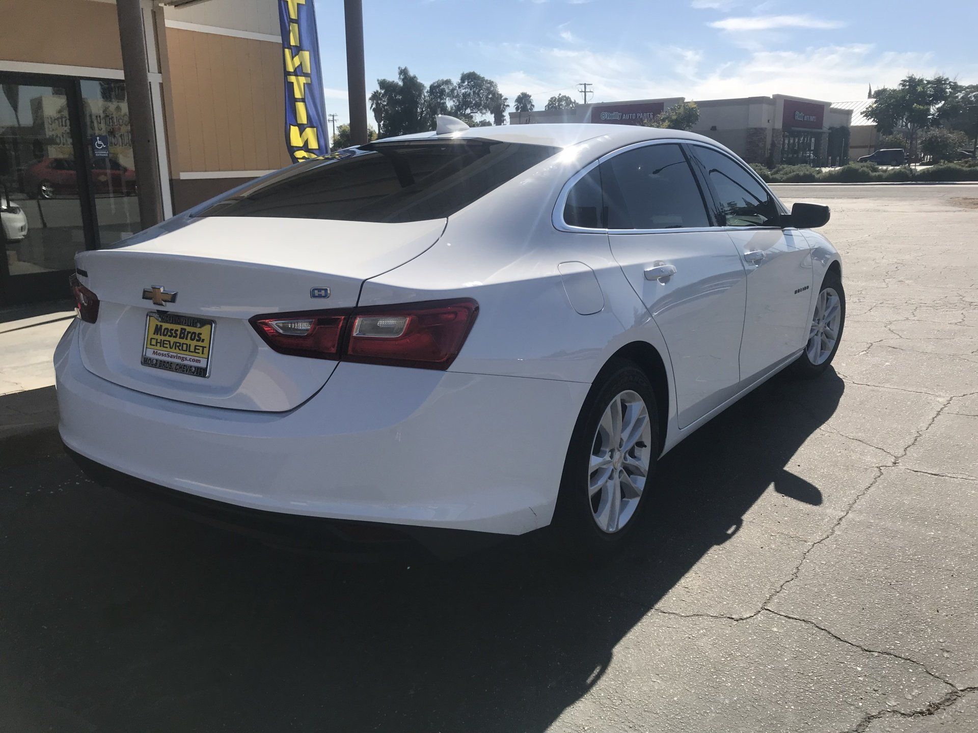 A white Chevrolet Malibu is parked in a parking lot