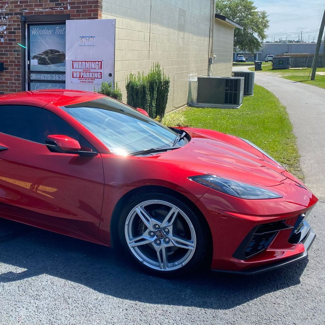 A red sports car is parked in front of a building
