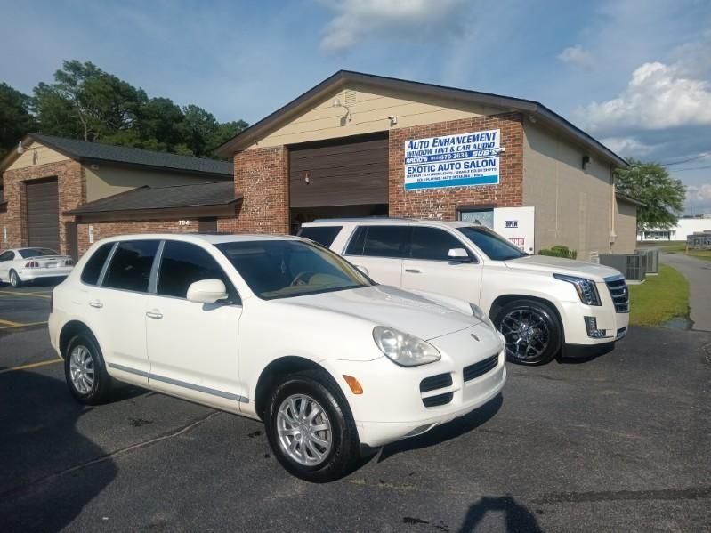 Two white cars are parked in front of a building.