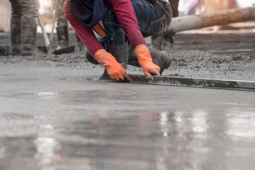 Construction Worker Spreading Concrete on the Ground — Adzcom Civils in Port Douglas, QLD