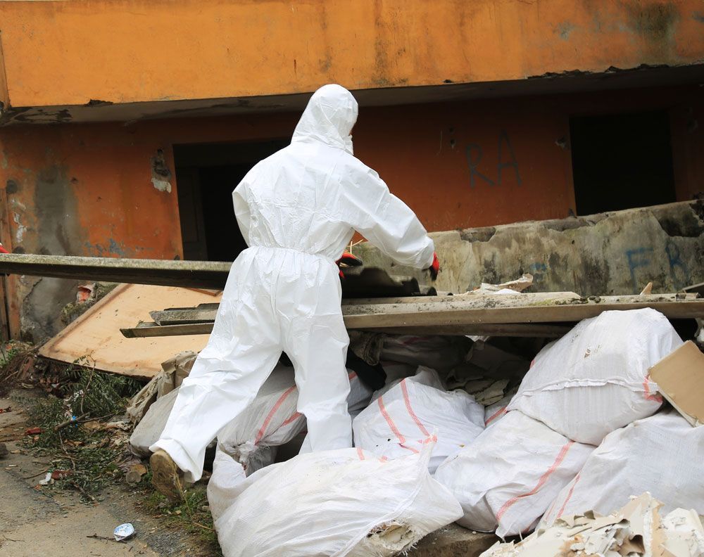 A Man in a Protective Suit Removing Asbestos — Adzcom Civils in Innisfail, QLD