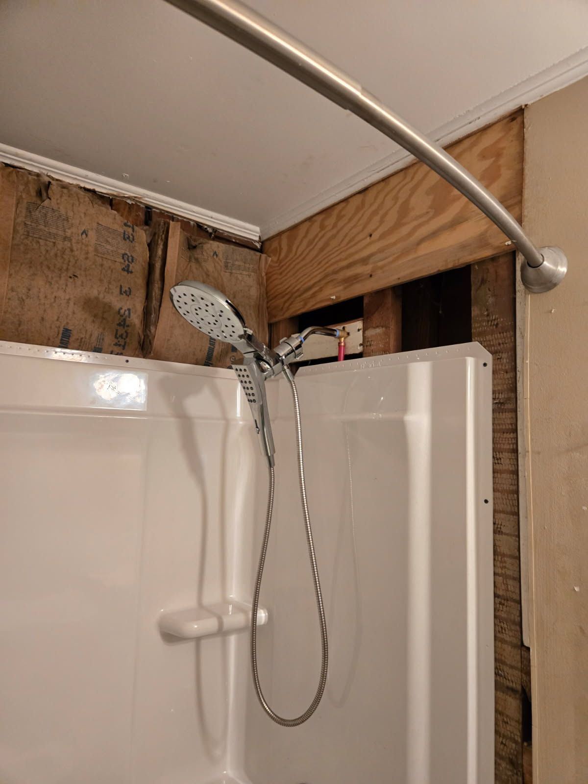 A shower head is hanging from the ceiling in a bathroom.
