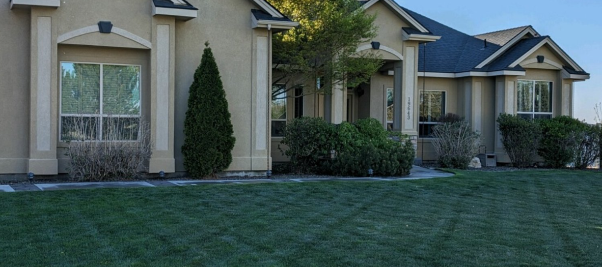 A large house with a lush green lawn in front of it.