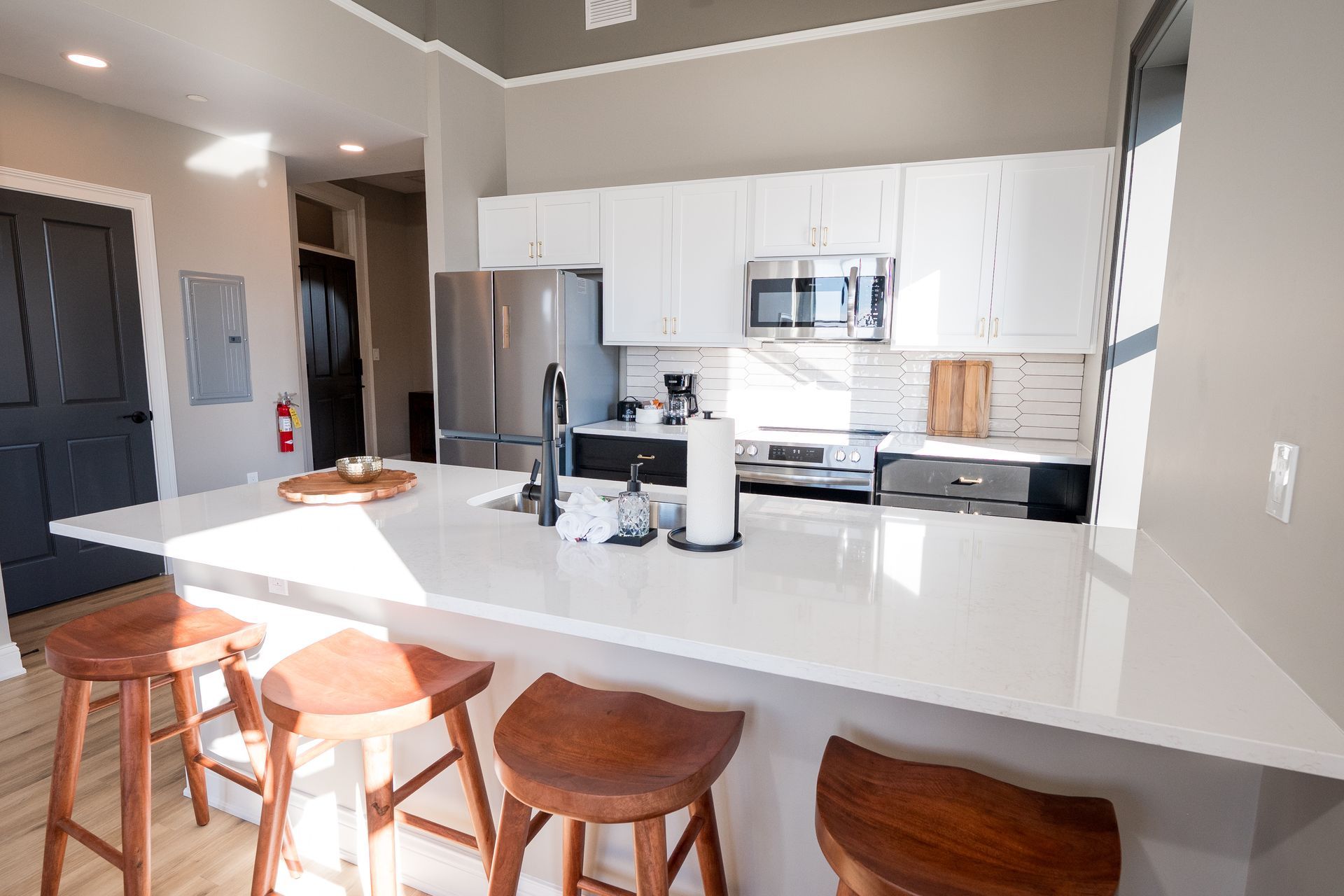 Modern kitchen with white cabinets, stainless appliances, and a large island with stools