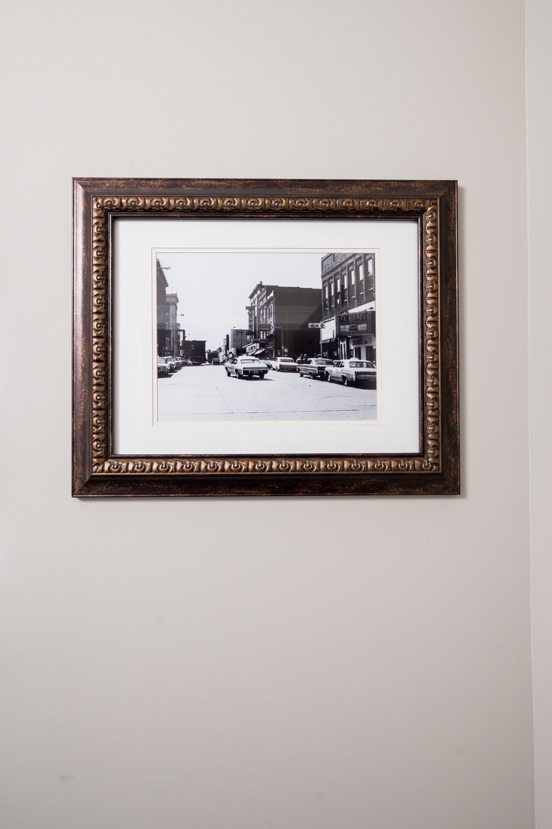 Framed black-and-white city street photo on a beige wall