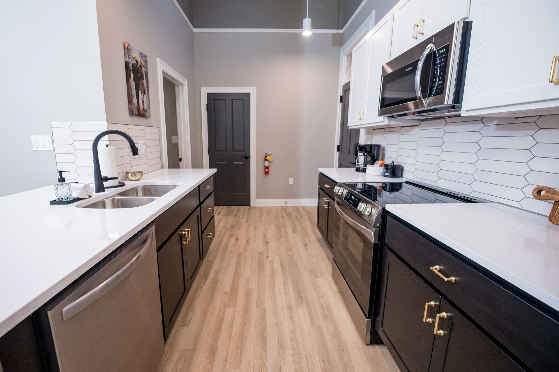 Modern kitchen with white cabinets, black appliances, and light wood flooring