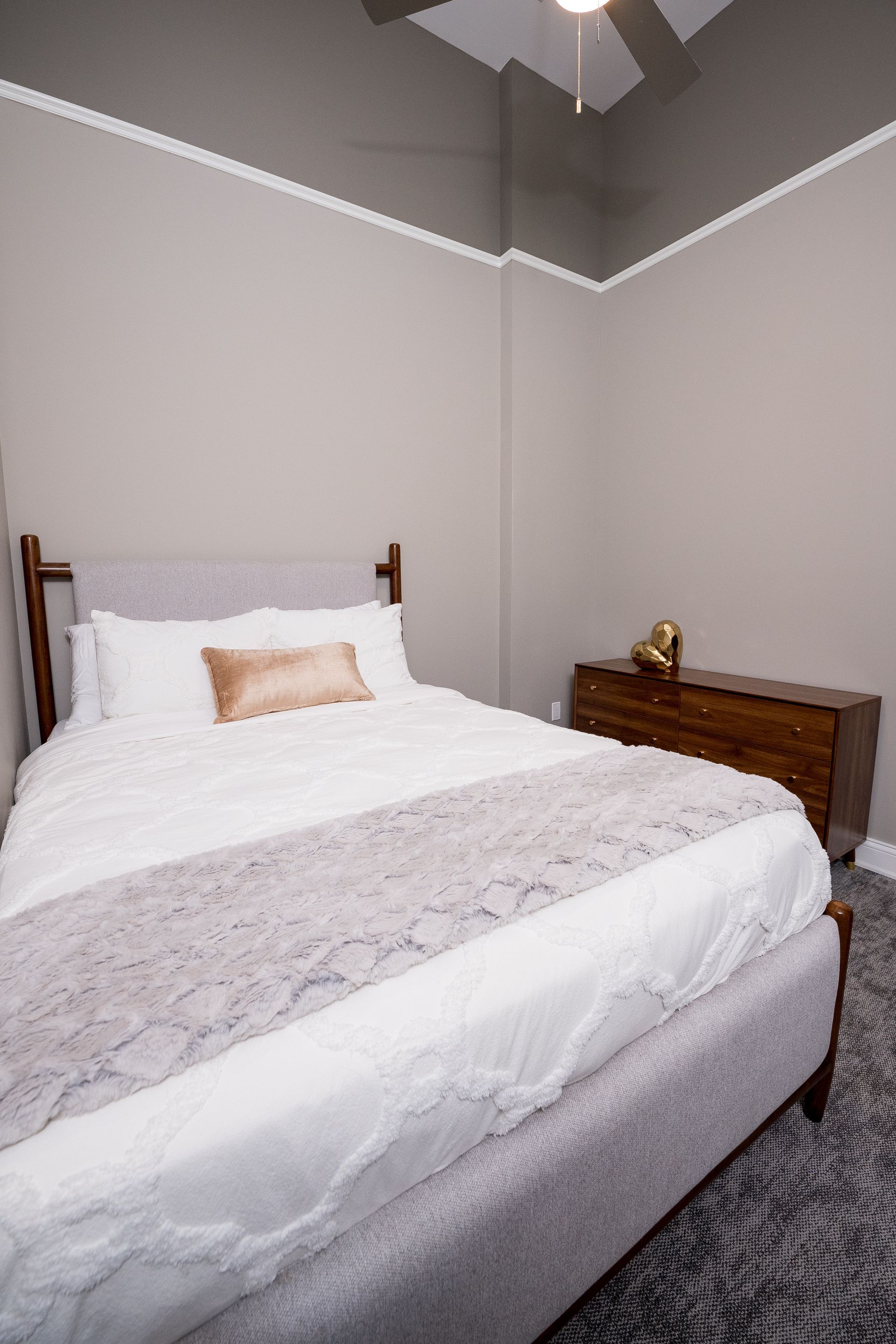 Small bedroom with a neatly made bed, white bedding, and a wooden nightstand.