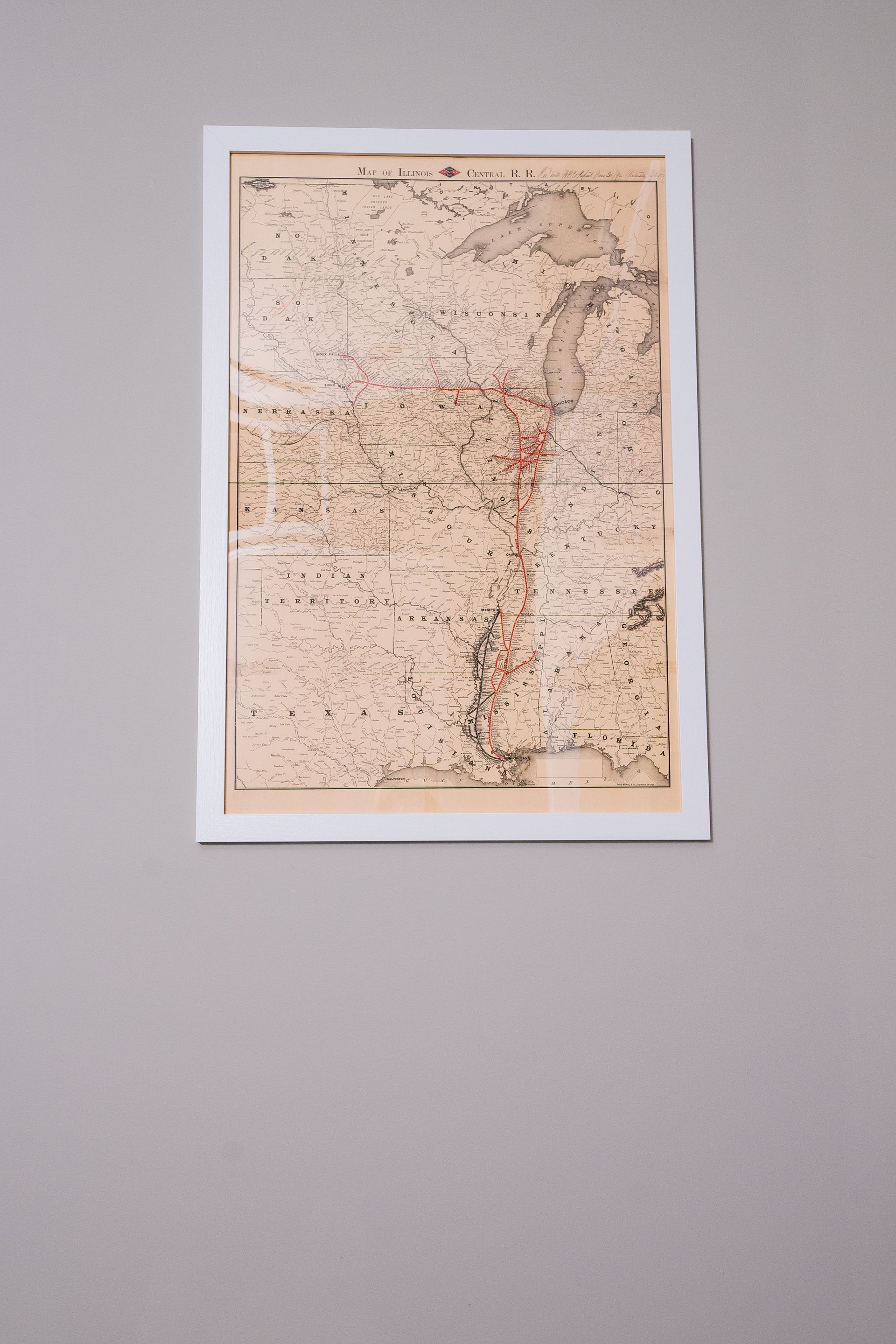 Framed vintage map on a light gray wall, centered in the shot.