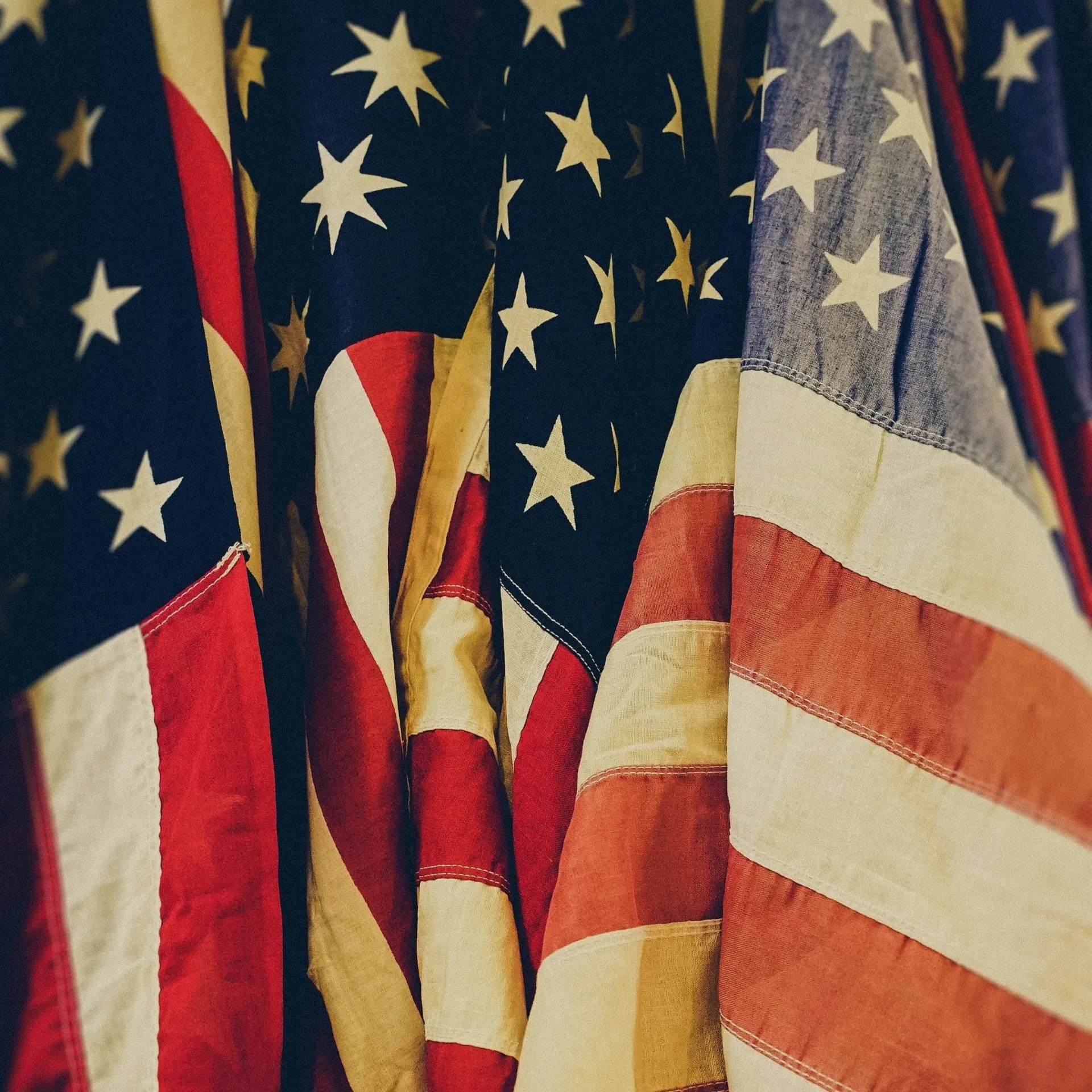 Close-up of overlapping American flags with red, white, and blue stars and stripes