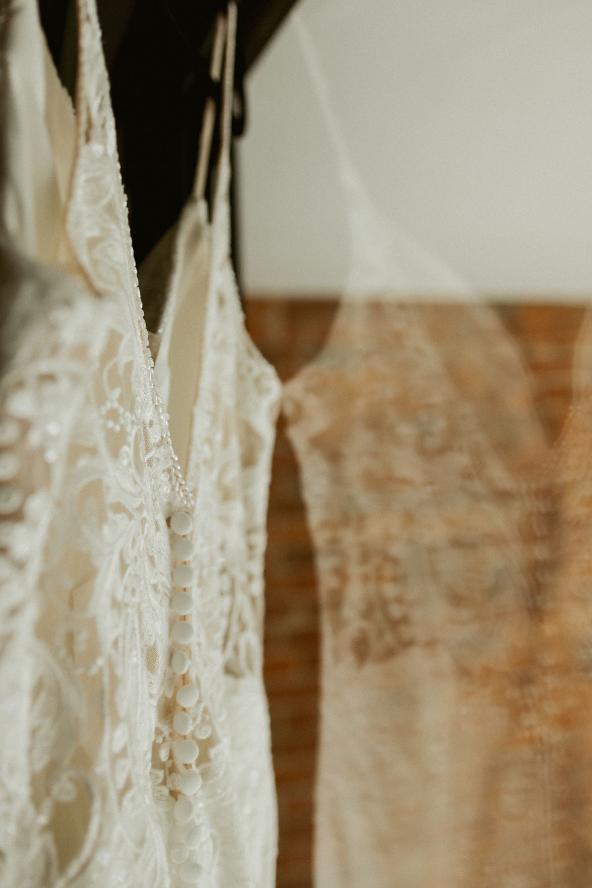 Close-up of hanging lace garments in white and beige against a soft indoor background