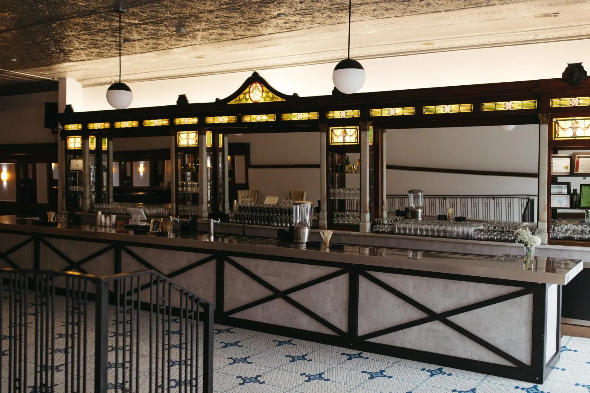 Empty bar counter with glassware and ornate wooden trim in a restaurant interior