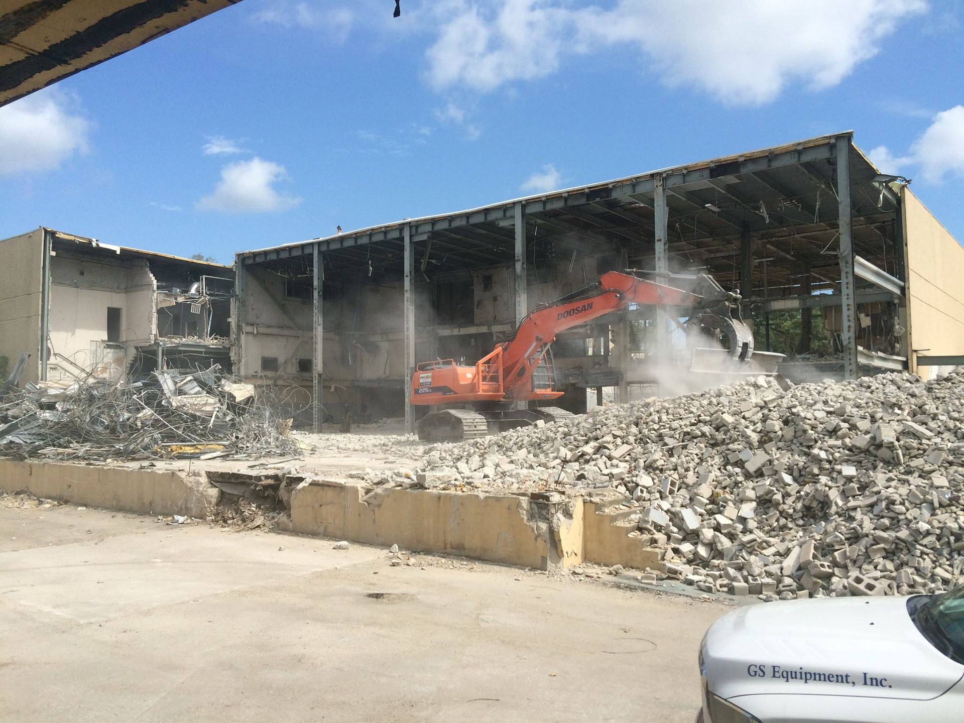 A yellow bulldozer is demolishing a building.