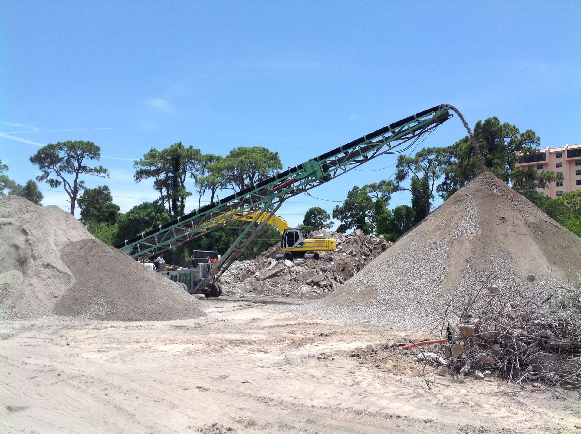A bulldozer is scooping up a pile of rocks and bricks.