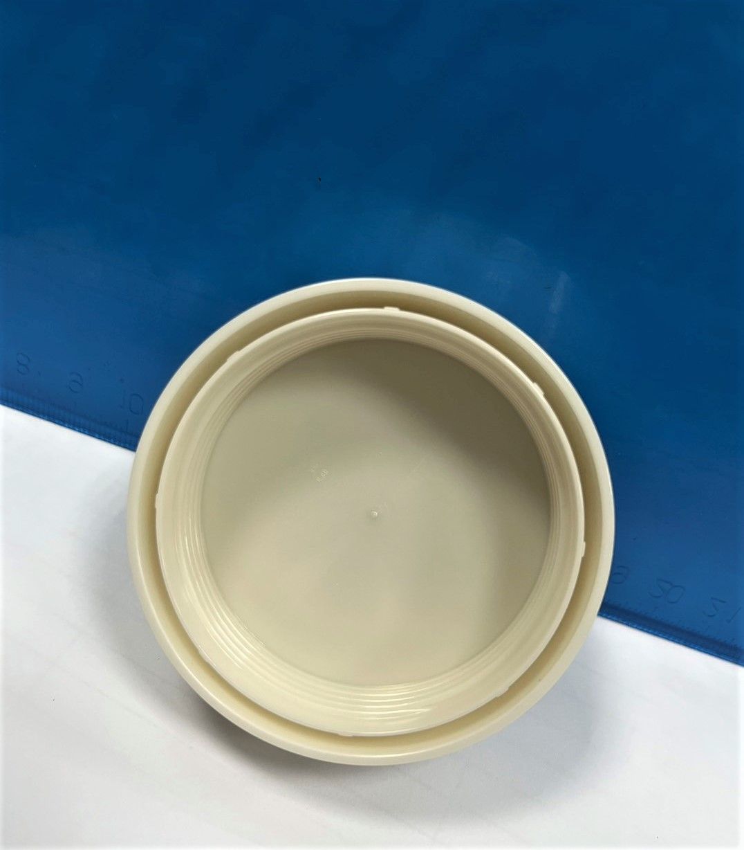 A white plastic plate is sitting on a white surface.