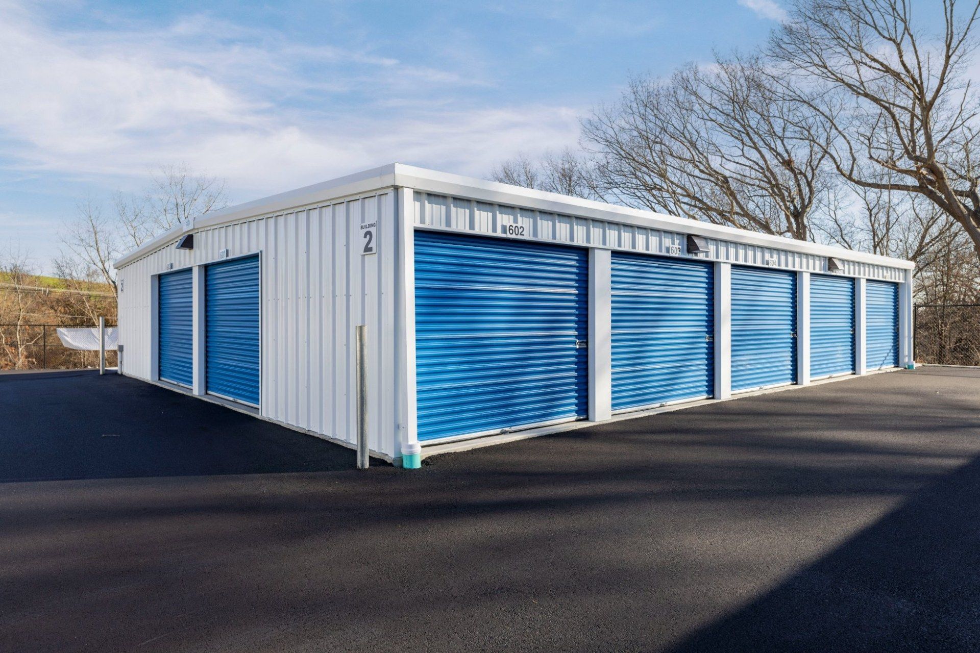 Drive-up storage units with blue roll-up doors at Storage Place in Cranston, RI