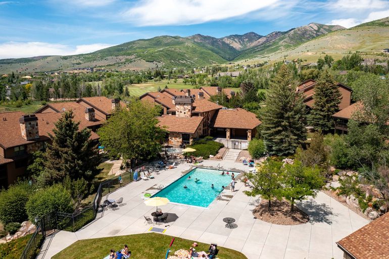 Wolf Creek Resort in Eden Utah showing an aerial view of the community swimming pool surrounded by buildings and trees.