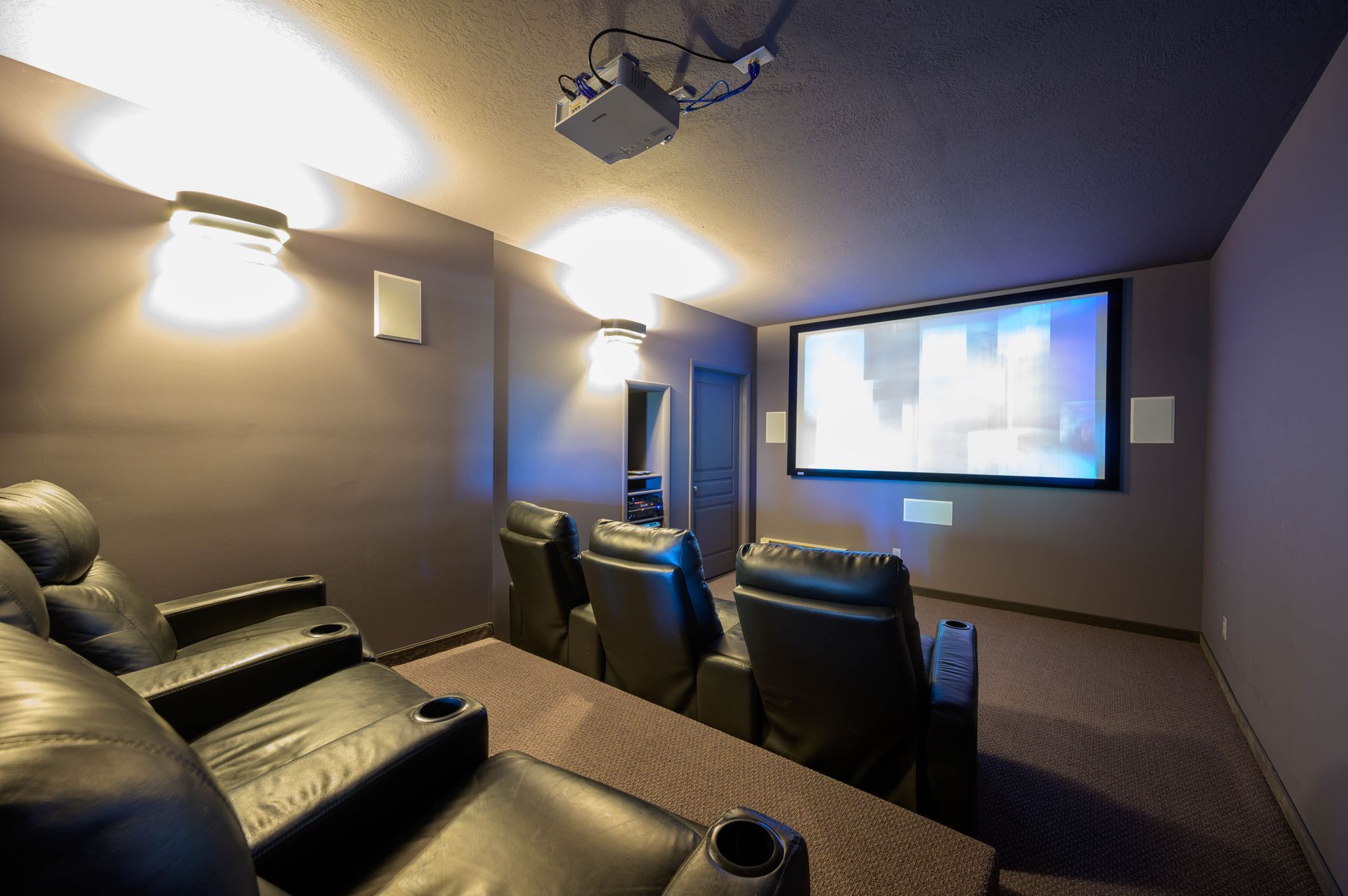 Theater room in a Elkhorn home, with comfortable seating, and large screen.