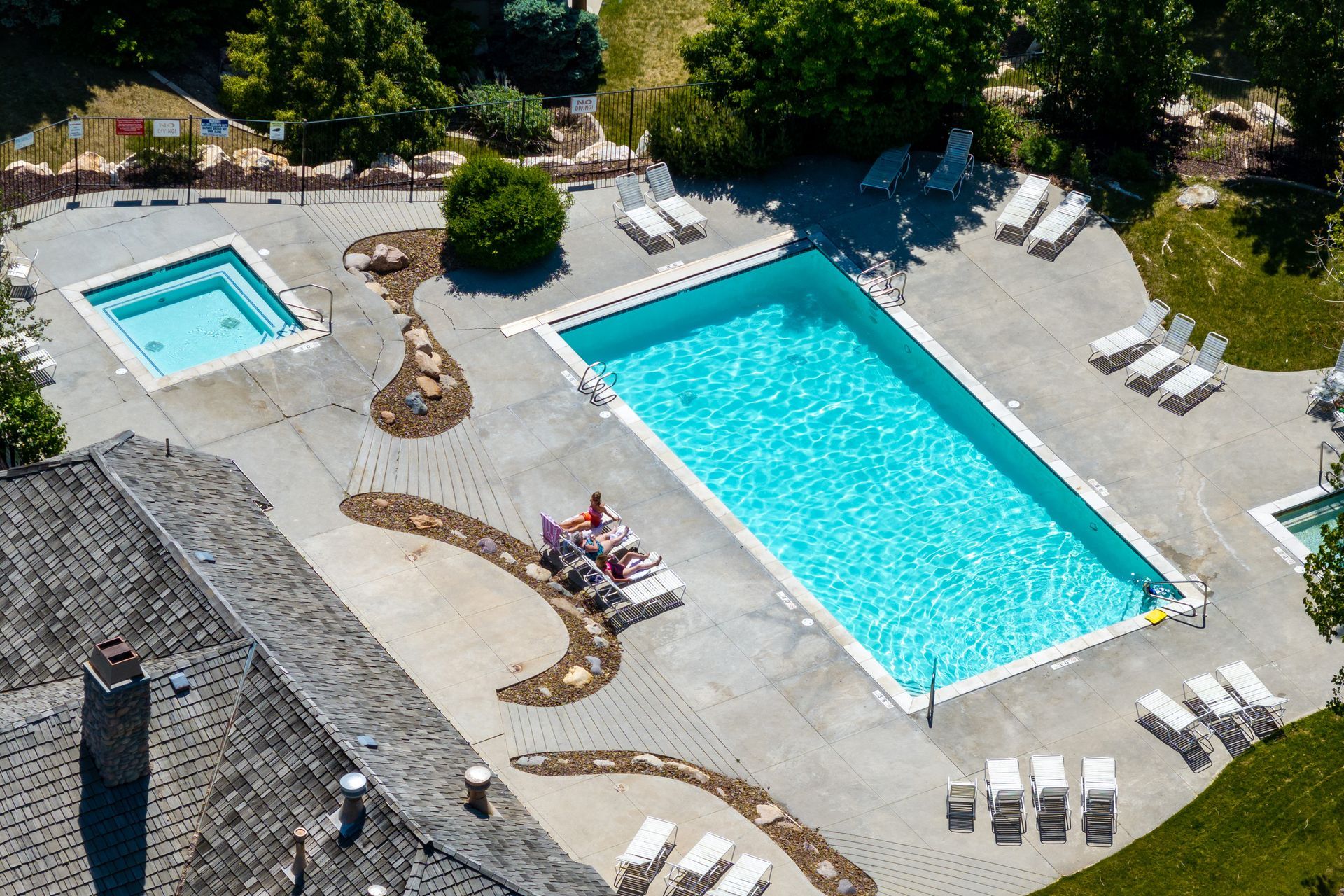 Moose Hollow Community swimming pool and hot tub, surrounded by lounge chairs and trees.