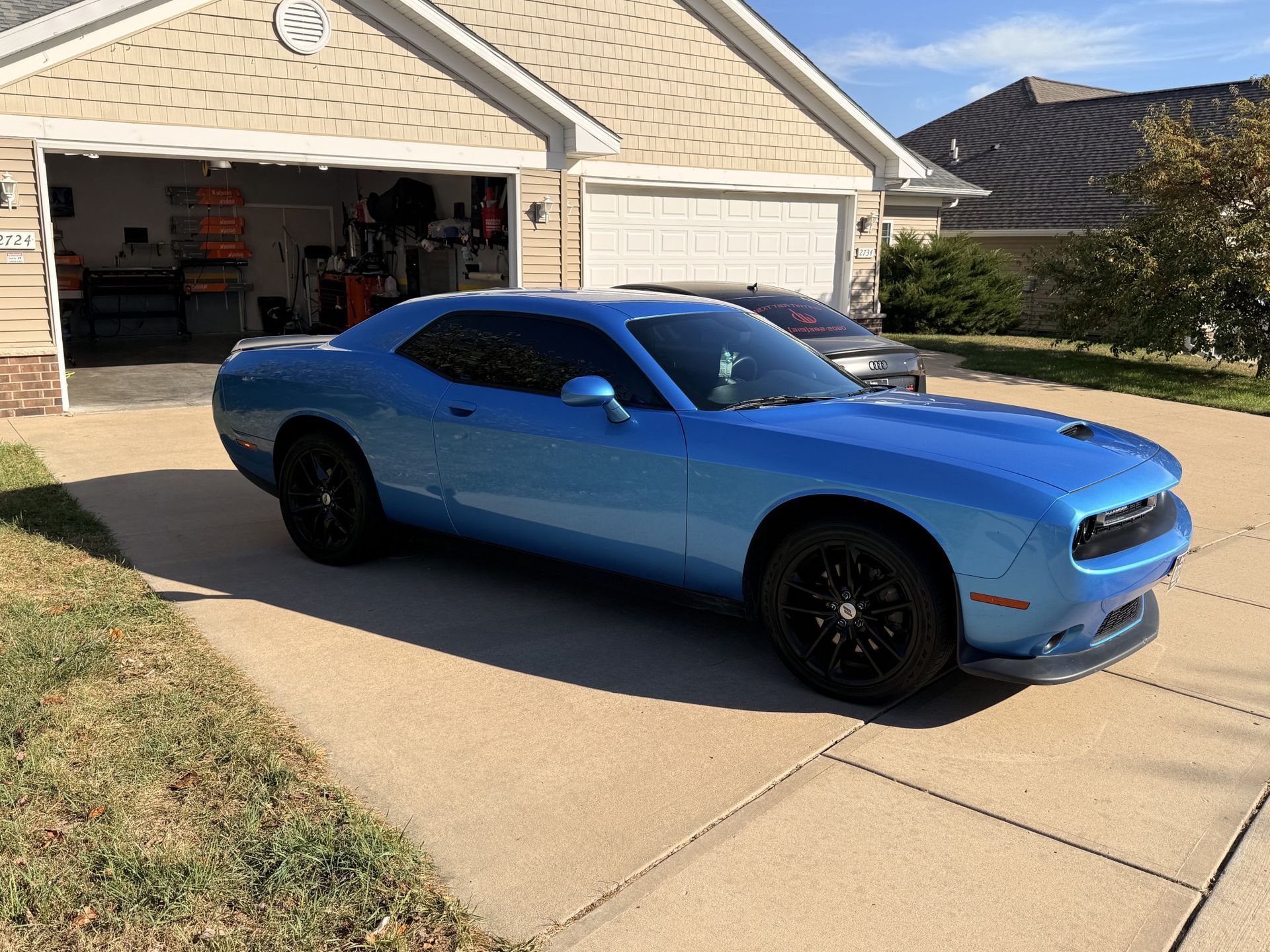 Blue Dodge Challenger muscle car with full window tint installation