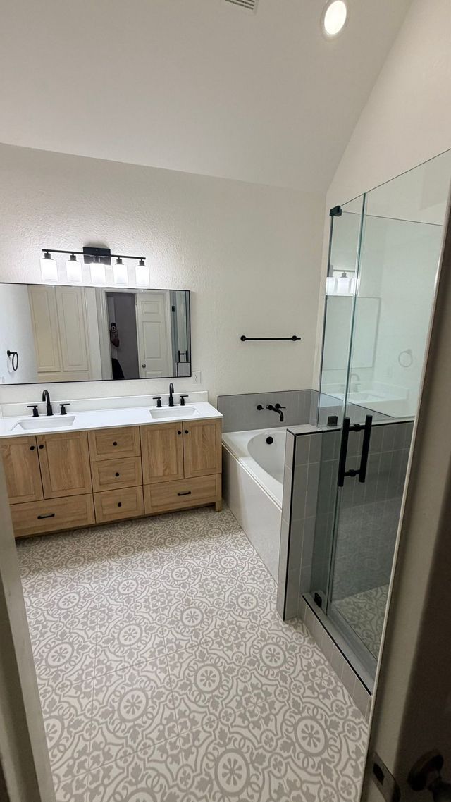 Modern bathroom with a glass shower, dark wood vanity, and toilet.