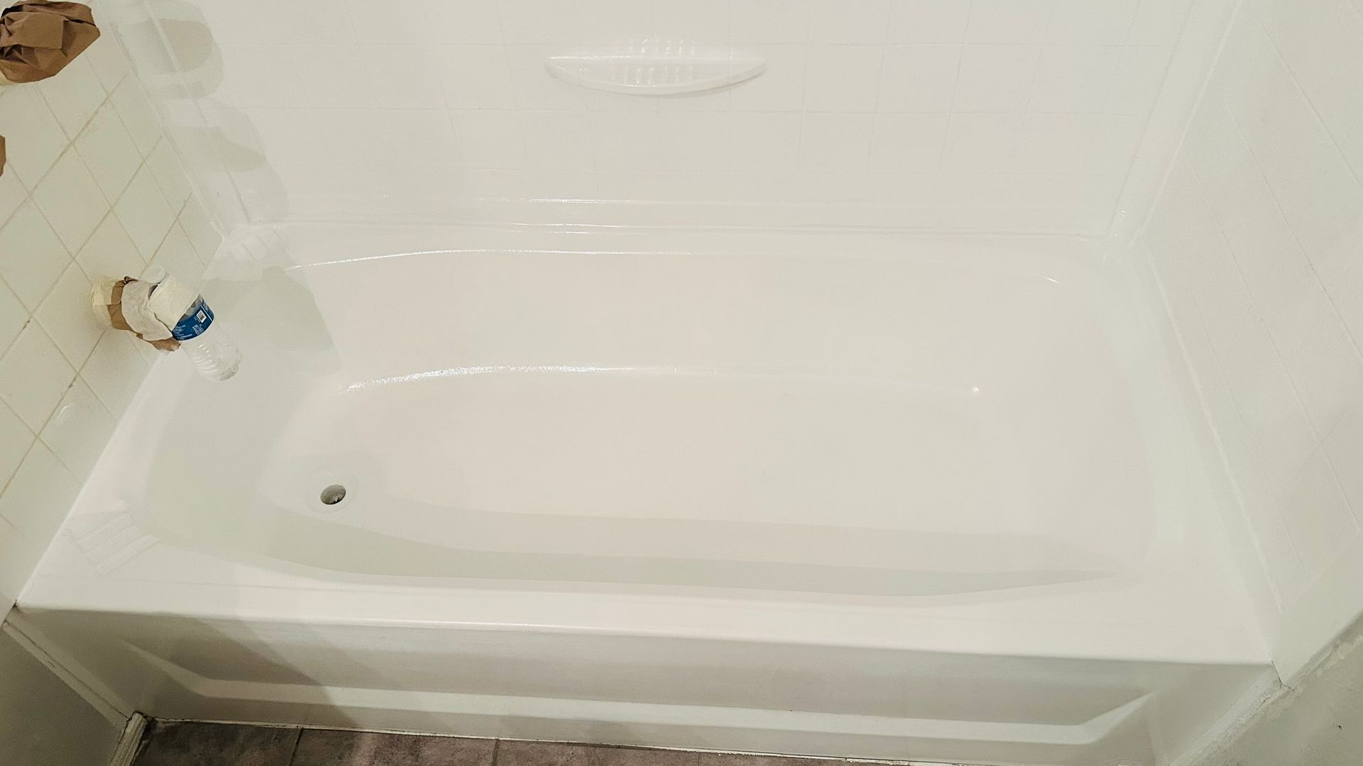 White bathtub in a tiled bathroom, viewed from above, newly renovated.